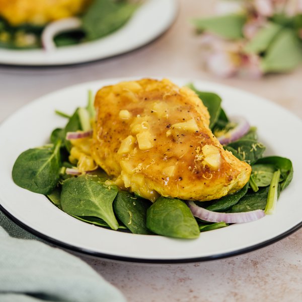 Chicken breasts with apricot sauce on a bed of mixed greens